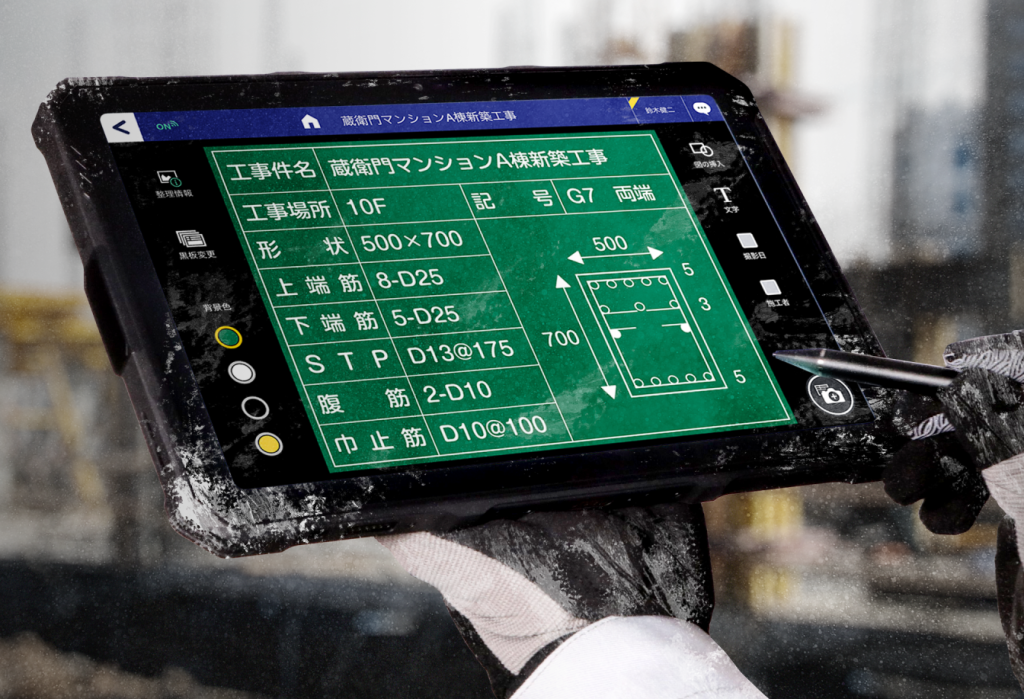 建設現場で業務用タブレット端末の配筋データを確認する様子